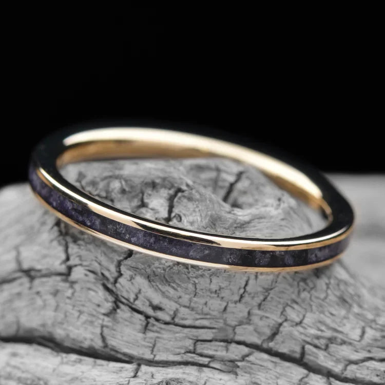 14K yellow gold wedding band with central amethyst inlay, 2mm womens ring, custom polished flat profile, free engraving, displayed on a white sea branch.