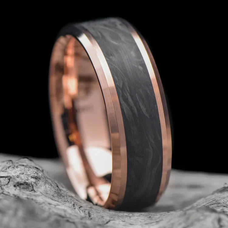 14K rose gold mens wedding band with central forged inlay, featuring a unique brushed bevel profile, 7mm wide, offering free engraving, displayed on a white sea branch.