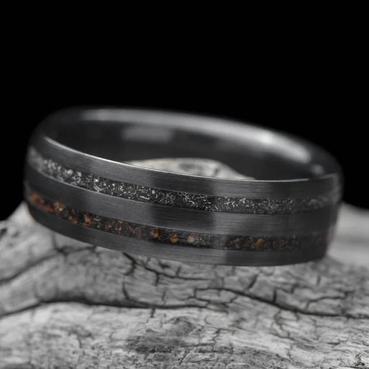 Black titanium wedding band with crushed T-Rex and meteorite inlays, 7mm mens ring, unique design, free engraving, displayed on a white sea branch.