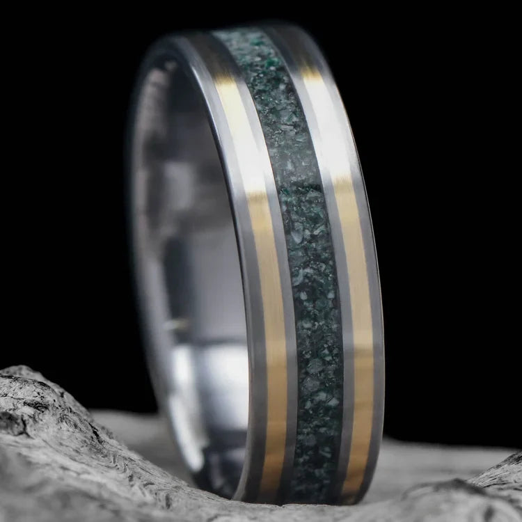 Tantalum wedding band with dual 14K yellow gold inlays, moss agate center, custom brushed finish, mens 6mm ring, free engraving, displayed on white sea branch.
