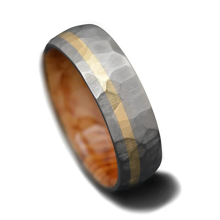 Titanium wedding band with 10KY gold and whiskey barrel oak inlay, 7mm mens ring featuring a unique faceted design, available with free engraving, displayed on a white background.