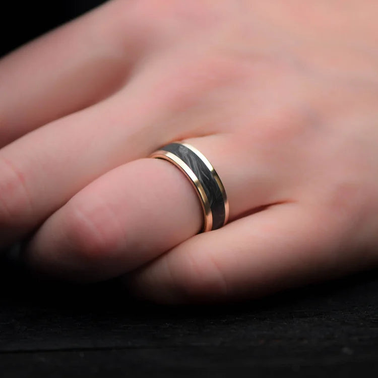 14K yellow gold mens wedding band with central forged inlay and forged inner sleeve, 7mm brushed flat profile, shown on a hand, free engraving available