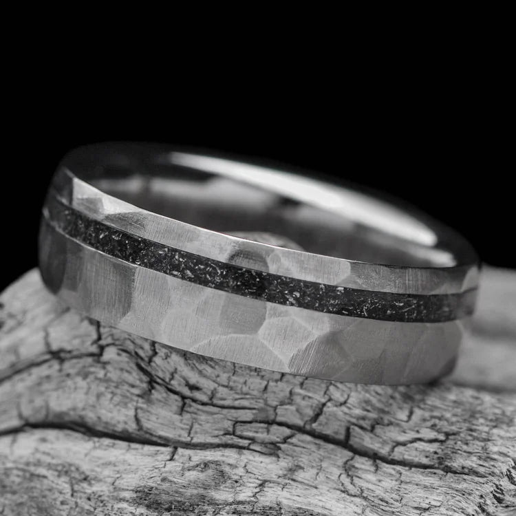 Titanium wedding band with meteorite inlay, 7mm mens ring featuring a unique faceted domed design, displayed on a white sea branch, free engraving available.