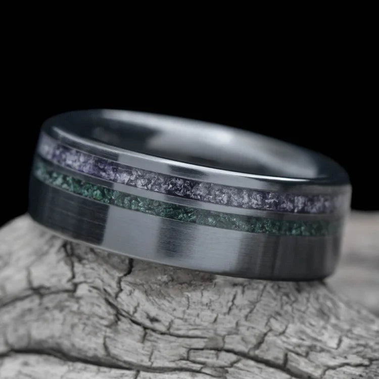 Black titanium wedding band with amethyst and moss agate inlays, 7mm mens ring, unique design, free engraving, displayed on white sea branch.