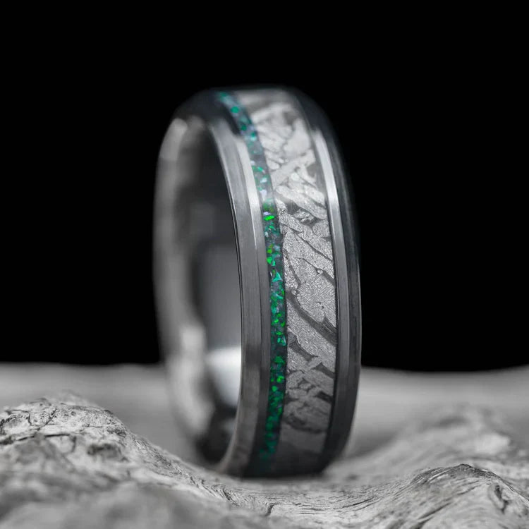 Black titanium wedding band with black emerald opal and meteorite inlays, 7mm mens ring, unique design, free engraving, displayed on a white sea branch.