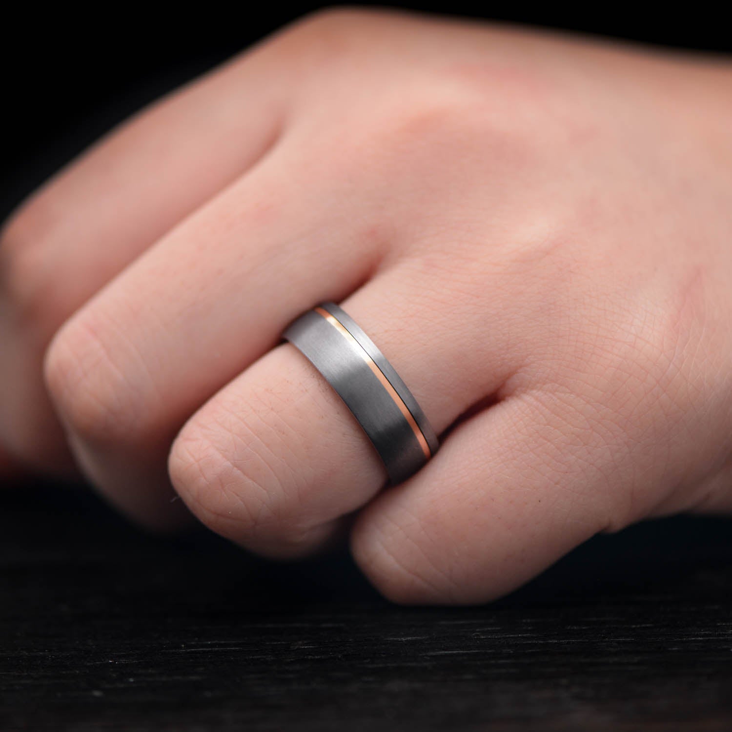 Tantalum wedding band with 18K rose gold inlay, 7mm mens sandblasted domed ring, unique mens wedding band, free engraving available, displayed on a white background.