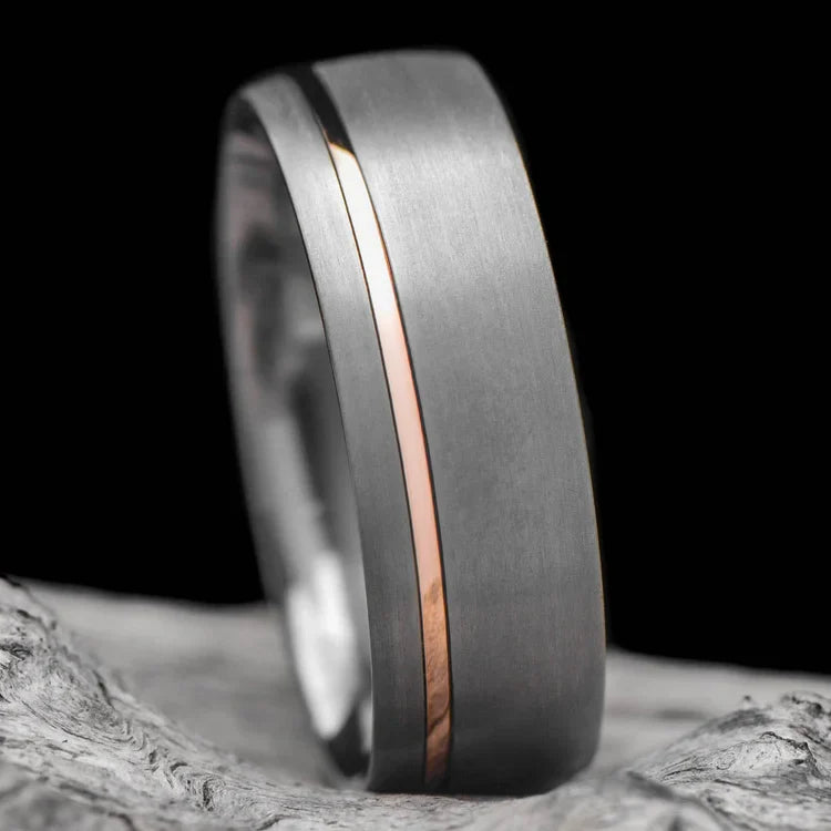 Tantalum wedding band with 18K rose gold inlay, featuring a 7mm sandblasted domed design, displayed on a white sea branch, ideal for mens unique wedding jewelry with free engraving option.
