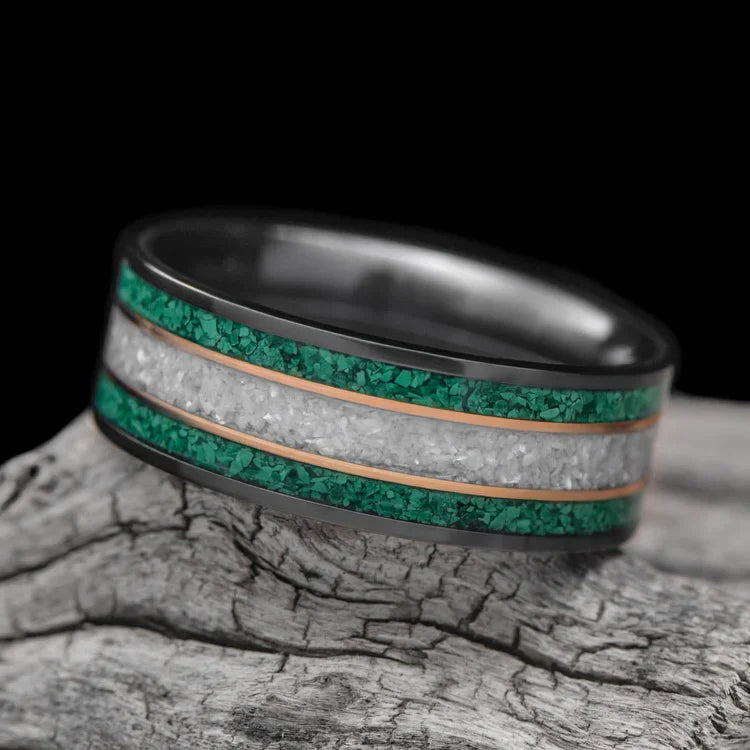 Black titanium wedding band with dual 14K yellow gold inlays and pearl center, 8mm mens ring, custom design, free engraving, displayed on white sea branch.