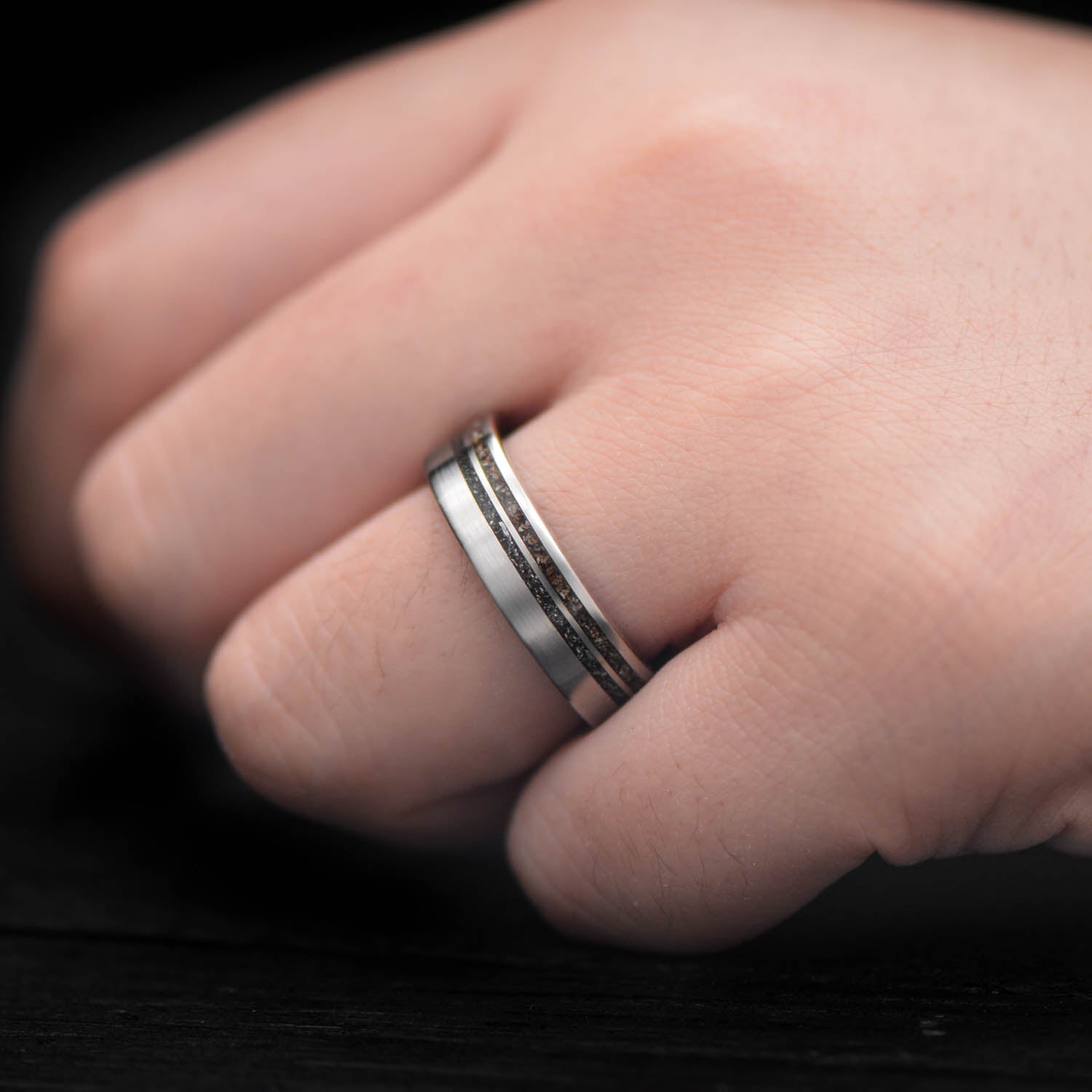 Titanium wedding band with crushed T-Rex and Western Maple Burl inlays, 6mm mens ring, unique custom design, free engraving, displayed on a white sea branch.