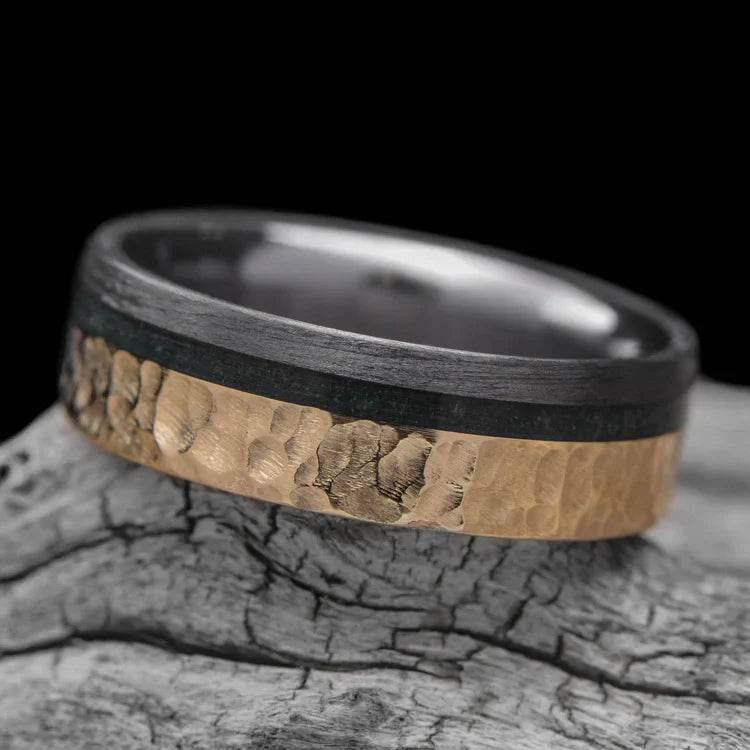 14KY mens wedding band with unidirectional and moss agate inlays, 7mm hammered flat profile, unique design, free engraving, displayed on a white sea branch.