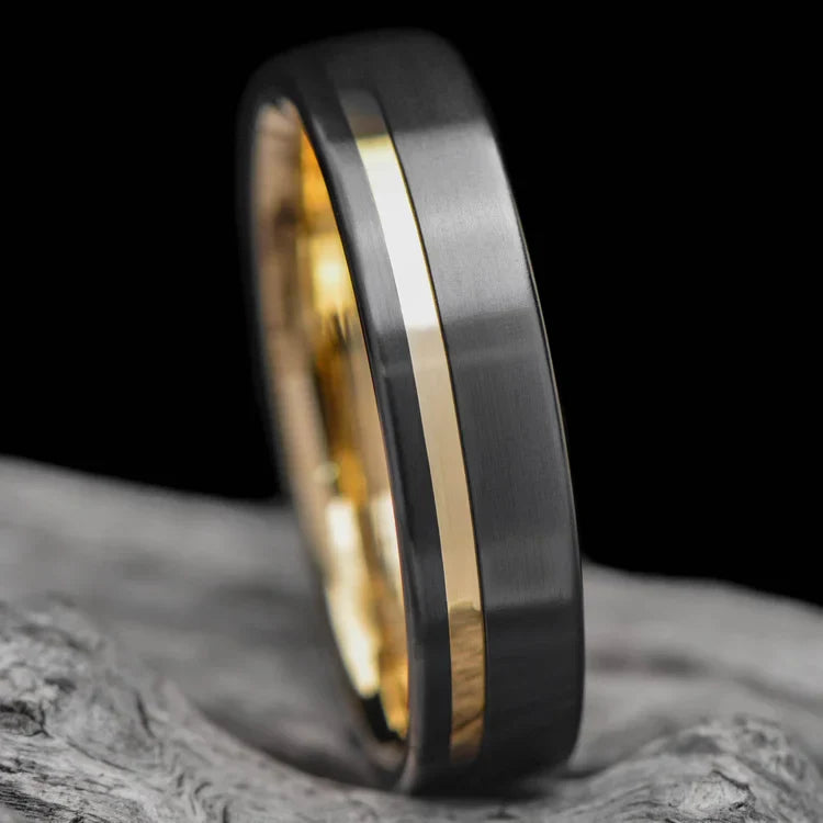 Black Titanium Wedding Band with 10KY Inlay, Mens 6mm Brushed Flat Profile Ring, Customizable with Free Engraving, displayed on a white sea branch.