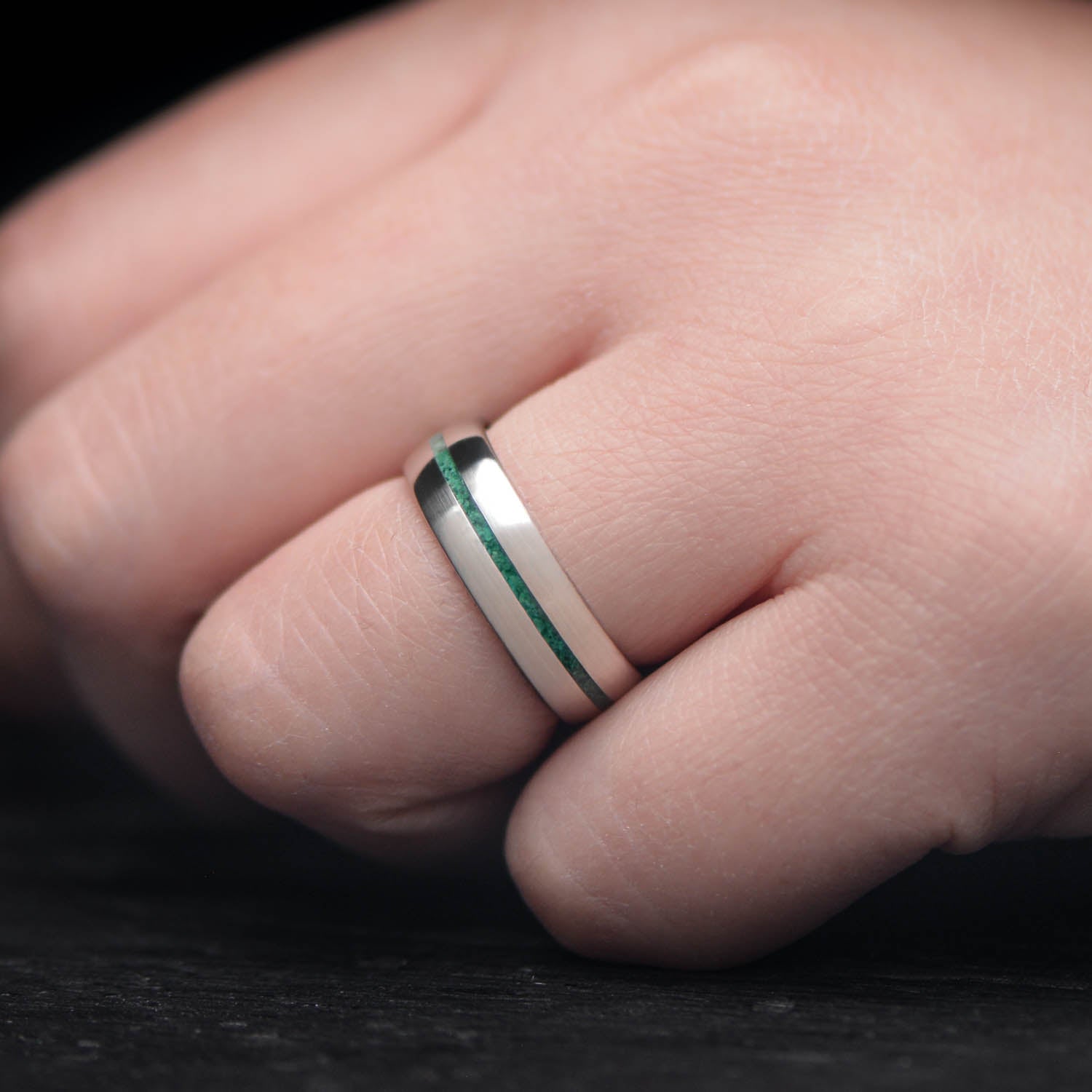 10KW mens wedding band with malachite inlay, brushed domed profile, 6mm width, unique custom ring with free engraving, displayed on a white sea branch.
