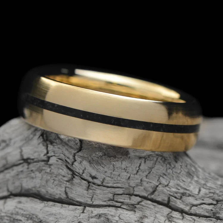 14K yellow gold mens wedding band with central black onyx inlay, 6mm brushed domed profile, unique design, free engraving, displayed on a white sea branch.