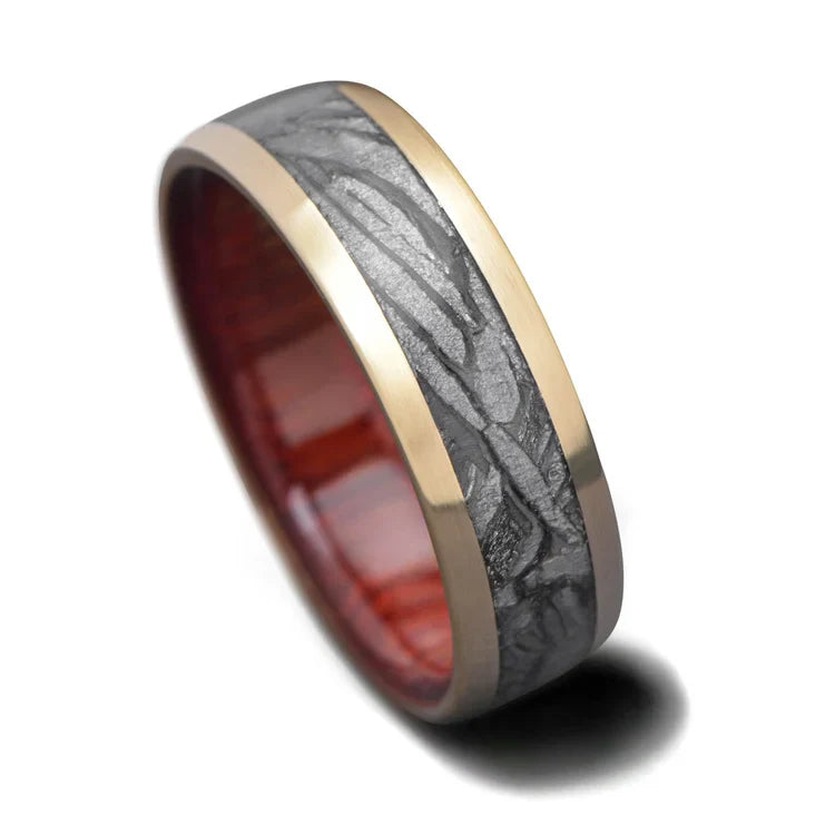 10K yellow gold wedding band with central meteorite inlay and bloodwood inner sleeve, 7mm mens ring, unique design, free engraving available, photographed on white background.