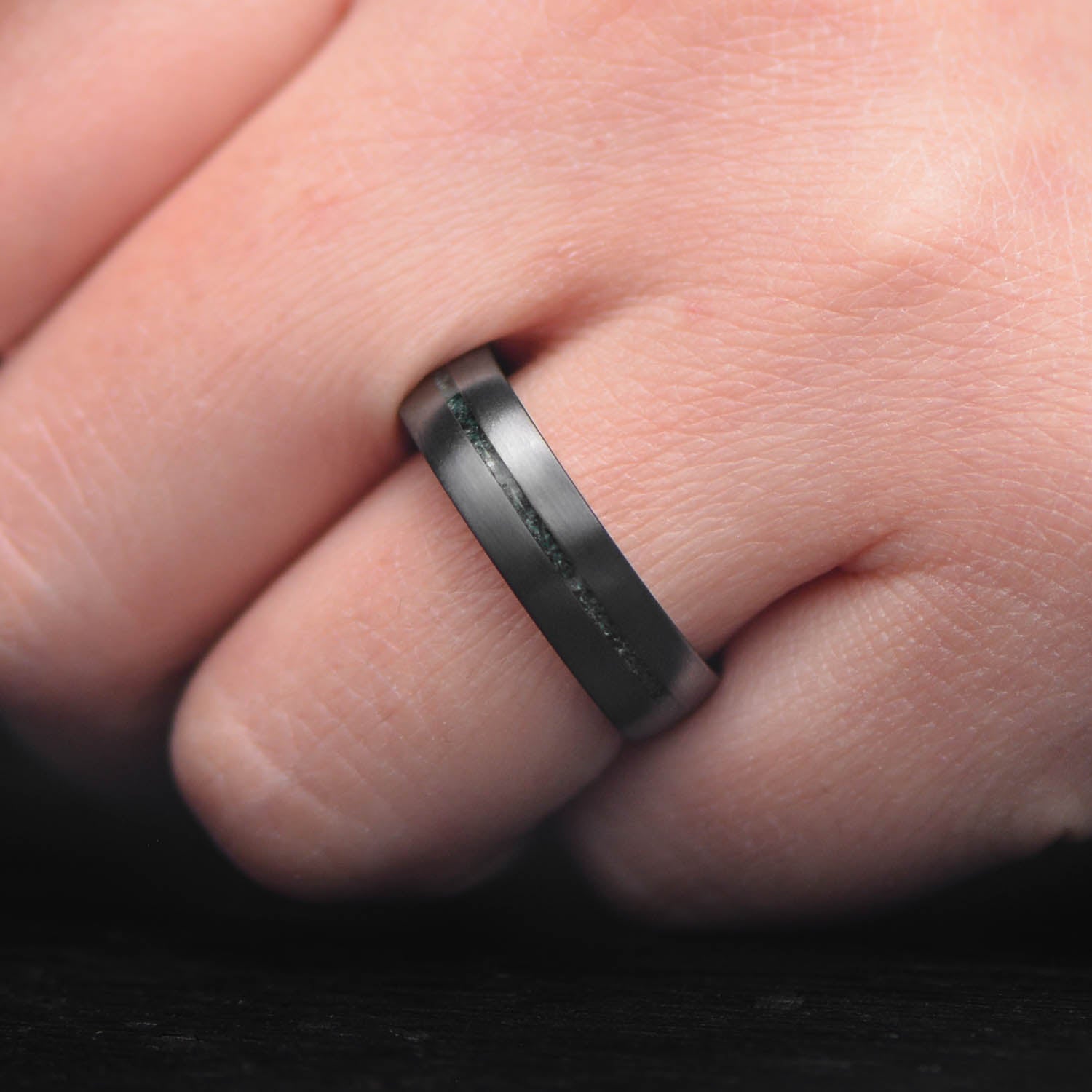 Zirconium wedding band with central moss agate inlay, 6mm mens ring, unique design, free engraving, displayed on a white sea branch.