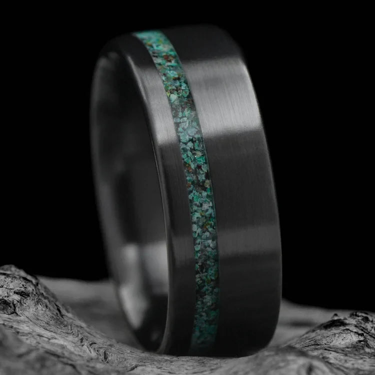 Black titanium wedding band with turquoise inlay, 8mm mens ring with unique brushed finish, free engraving, displayed on white sea branch.
