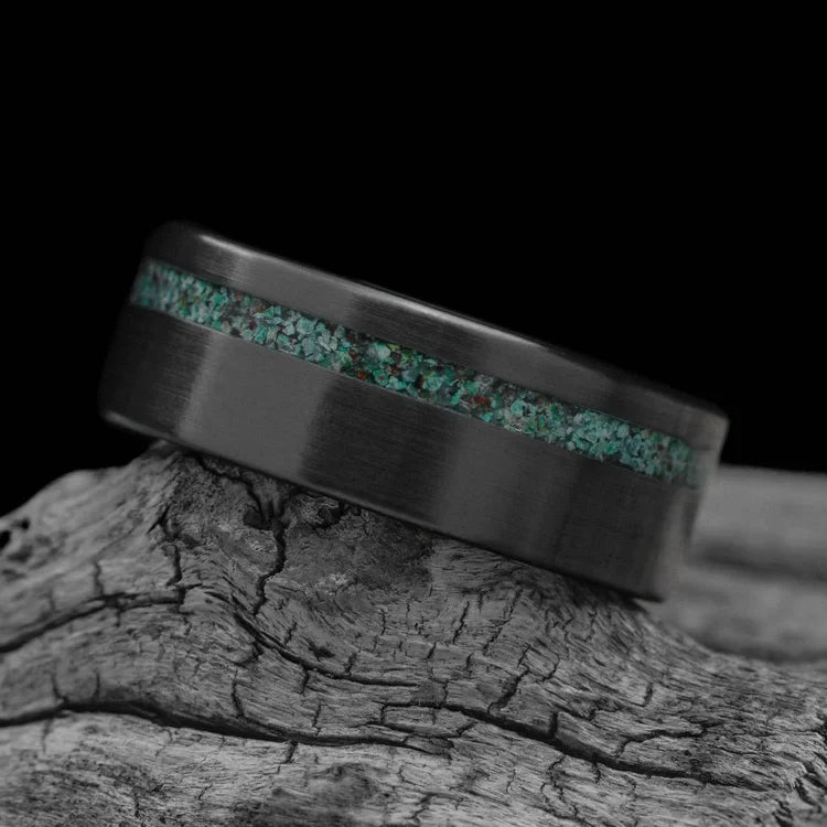 Black titanium wedding band with turquoise inlay, 8mm mens ring, unique brushed finish, free engraving, displayed on white sea branch.
