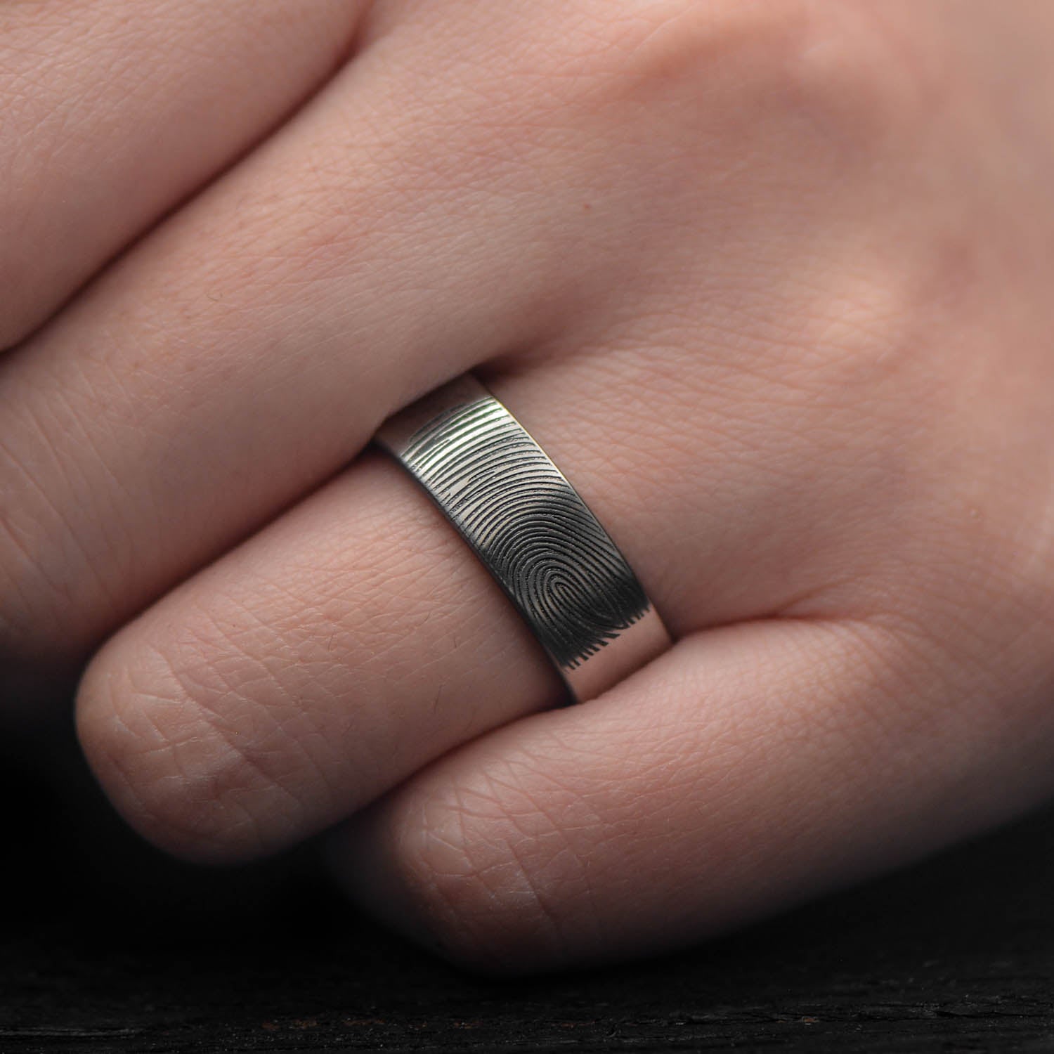 Mens 7mm titanium wedding band with whiskey barrel oak inner sleeve, featuring a brushed flat profile, available with free engraving, displayed on a white background.