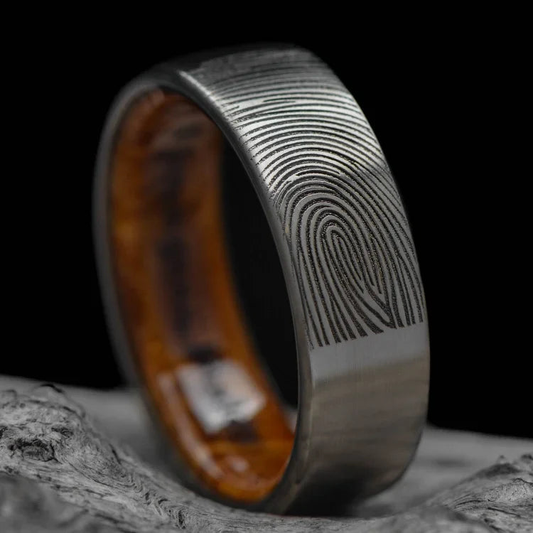 Titanium wedding band with whiskey barrel oak inner sleeve, 7mm brushed flat profile, mens ring on white sea branch, free engraving available.