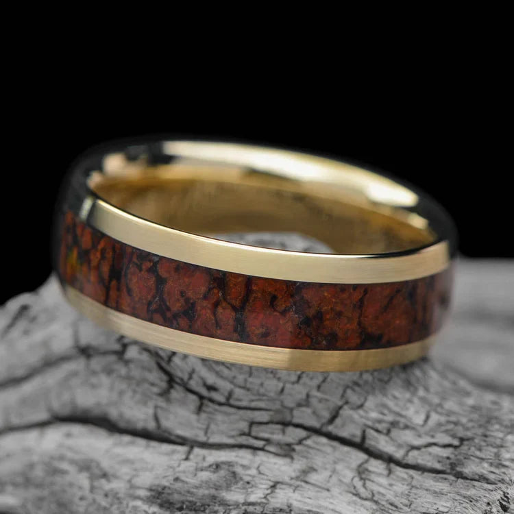 10KY gold mens wedding band with solid T-Rex central inlay, 7mm unique custom design, free engraving, displayed on white sea branch.