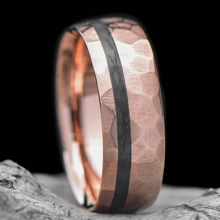 14K rose gold mens wedding band with unidirectional inlay, 7mm faceted domed profile, custom ring with free engraving, shown on a hand.