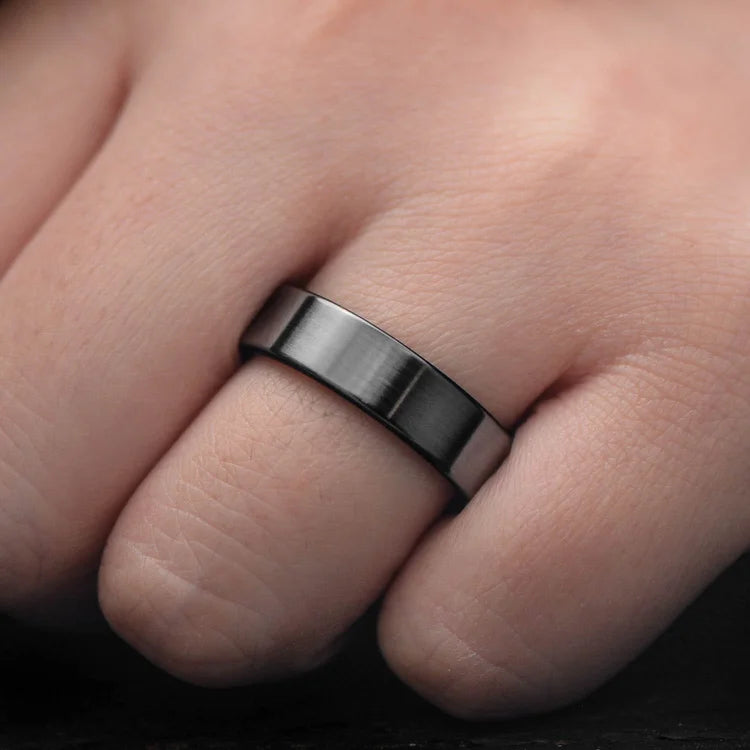Black titanium wedding band with silver spalted birch inner sleeve, 6mm mens ring, unique design, free engraving, displayed on a white sea branch.