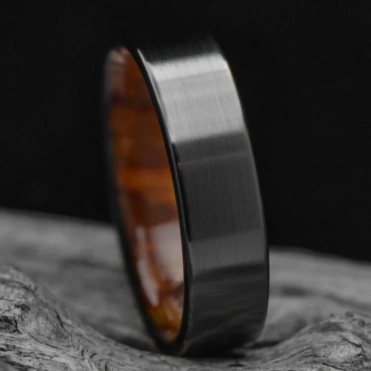 Black titanium wedding band with silver spalted birch inner sleeve, 6mm mens ring, unique design, free engraving, displayed on white sea branch.