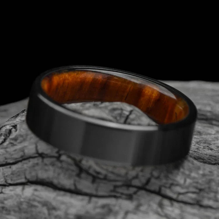 Black titanium wedding band with silver spalted birch inner sleeve, 6mm mens ring, unique design, free engraving, displayed on a white sea branch.