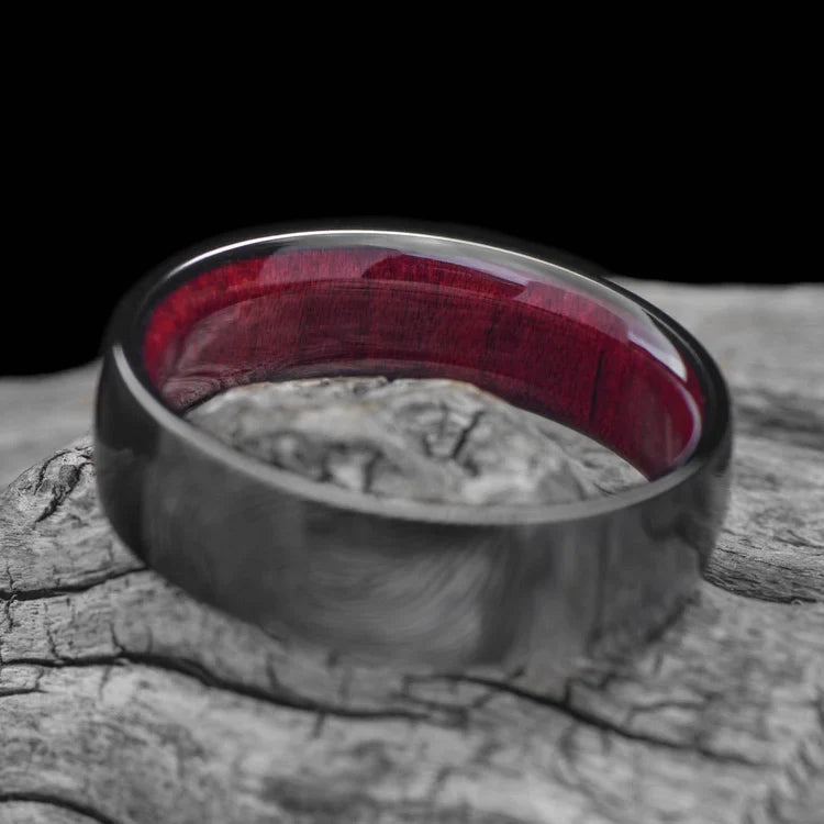 Black Titanium Wedding Band with Bloodwood Inner Sleeve, 7mm Mens Domed Polished Ring, Unique Mens Wedding Band, displayed on a white sea branch, free engraving available.