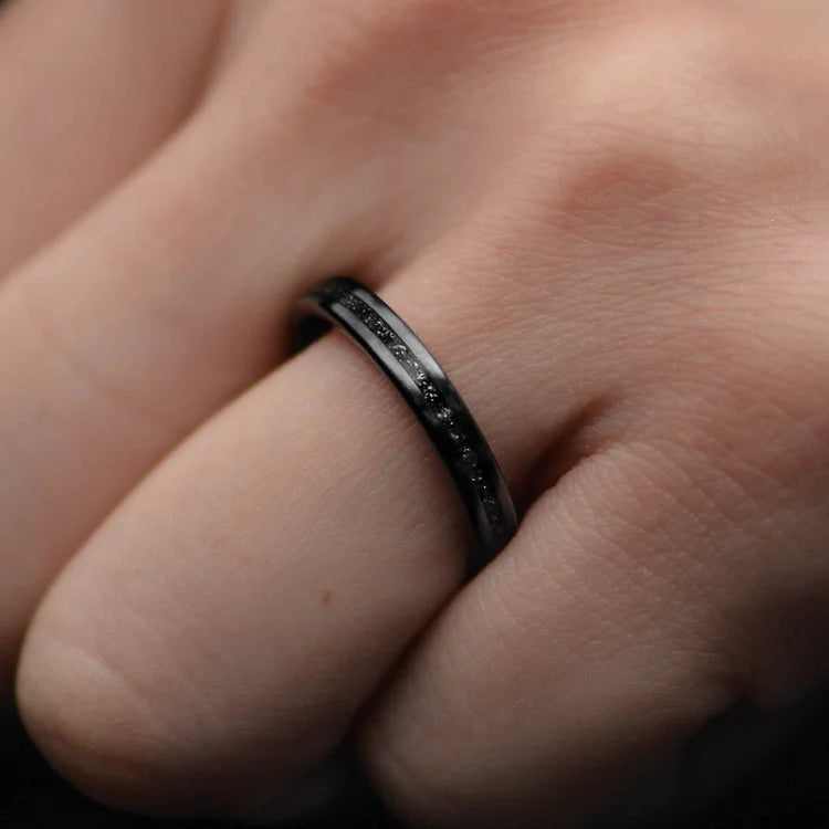 Black Titanium meteorite inlay, 3mm womens unique custom ring, free engraving, displayed on a white sea branch.