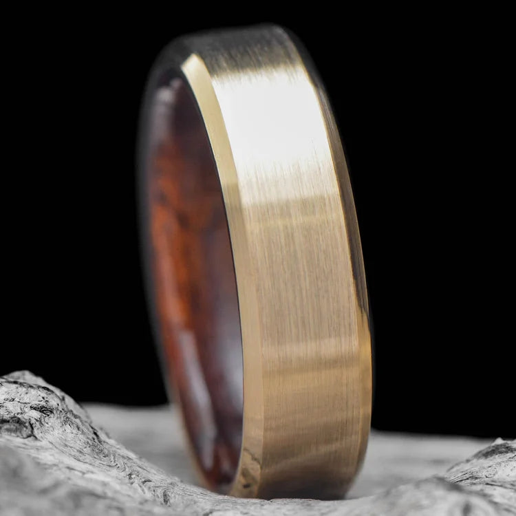 14K yellow gold mens wedding band with teak inner sleeve, featuring a brushed bevel profile, 6mm width, shown on a hand, custom ring with free engraving option.