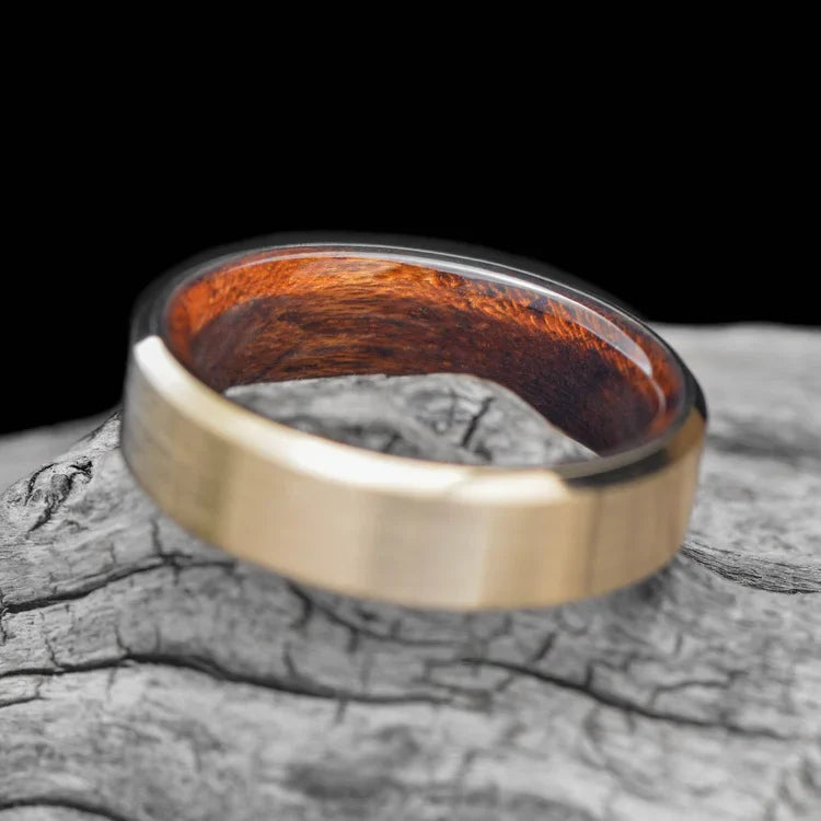 14KY gold wedding band with teak inner sleeve, featuring a brushed bevel profile, 6mm mens ring, custom design, free engraving, displayed on a white sea branch.