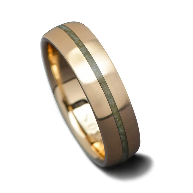 14K yellow gold mens wedding band with custom inlay and central emerald, brushed domed design, 6mm width, free engraving option, displayed on a white background.