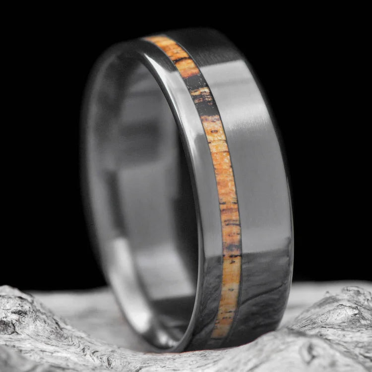 Mens black titanium wedding band with silver spalted birch inlay, 7mm polished flat profile, shown on a hand, free engraving available.
