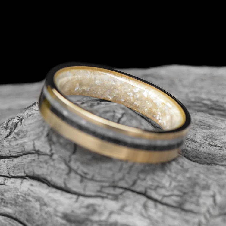 14K yellow gold wedding band with pearl and meteorite inlays, brushed flat profile, 5mm width, custom simple design, unique wedding band, free engraving, displayed on a white sea branch.