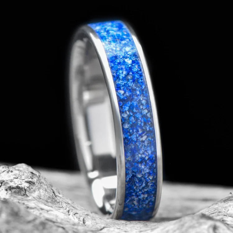 Titanium wedding band with central lapis lazuli inlay, 5mm unique custom simple ring, free engraving, displayed on a white sea branch.
