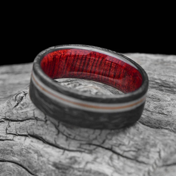 Mens 8mm wedding band featuring a forged design with dual deer antler and central guitar string inlays, bloodwood sleeve, brushed finish, displayed on a white sea branch.