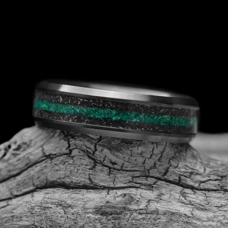 Black Titanium Wedding Band with Dual Meteorite and Central Malachite Inlays, 6mm Mens Wedding Ring, displayed on a white sea branch, showcasing its unique design and free engraving option.