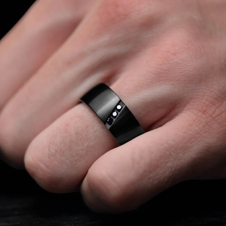 Mens black titanium wedding band with flush set diamond, 9mm brushed flat profile, unique design, free engraving, shown on hand.