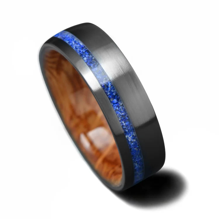 Black titanium ring with lapis lazuli inlay and whiskey barrel oak sleeve, 7mm mens wedding band, unique design, available with free engraving, displayed on a white background.