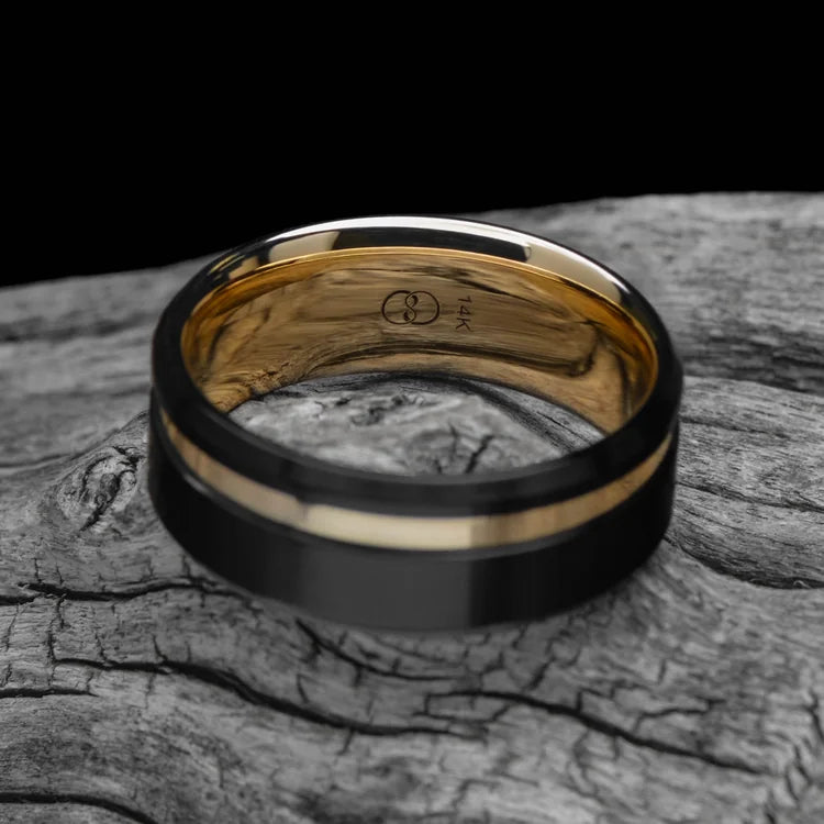 Black titanium wedding band with 14K yellow gold inlay and brushed bevel profile, 8mm mens ring, custom design, free engraving, displayed on white sea branch.