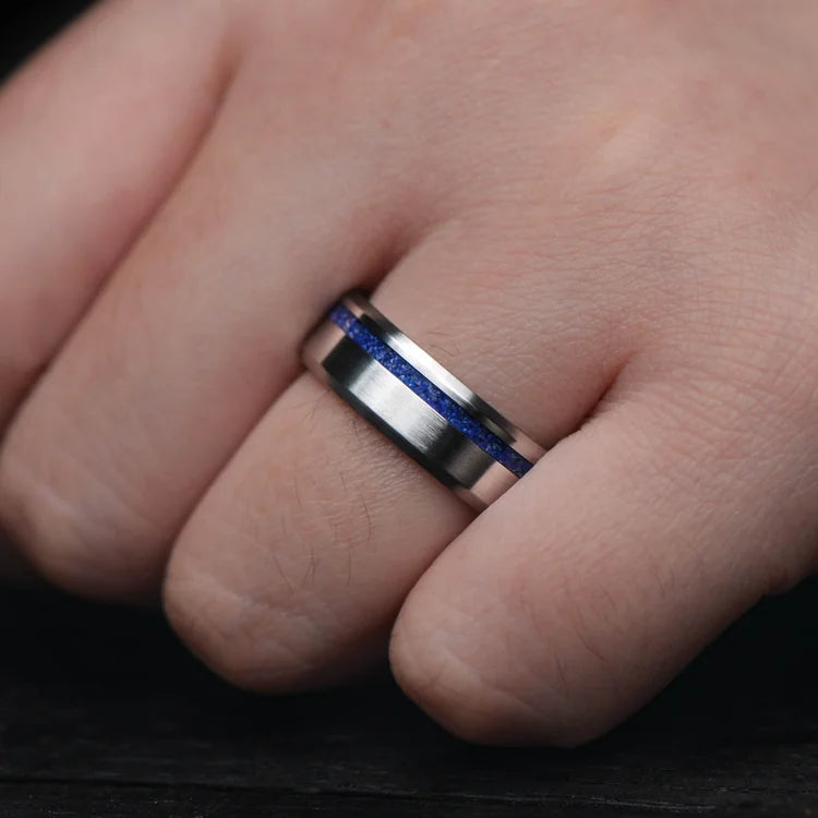 Mens titanium wedding band with lapis lazuli inlay, 7mm brushed bevel profile, unique design, free engraving, shown on hand.