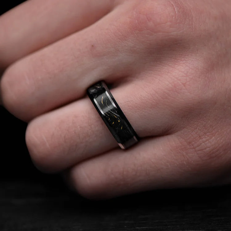 Black titanium mens wedding band with gilded forged inlay, 7mm width, polished bevel profile, unique design, free engraving, shown on a hand.
