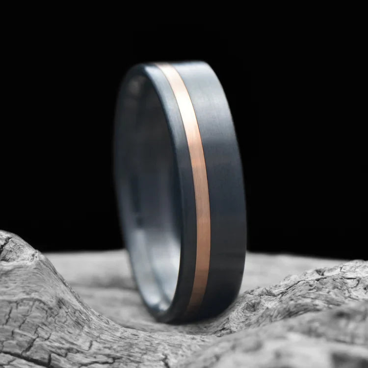 Zirconium wedding band with 14K rose gold inlay, 6mm men's ring, brushed flat profile, unique design, on white sea branch.