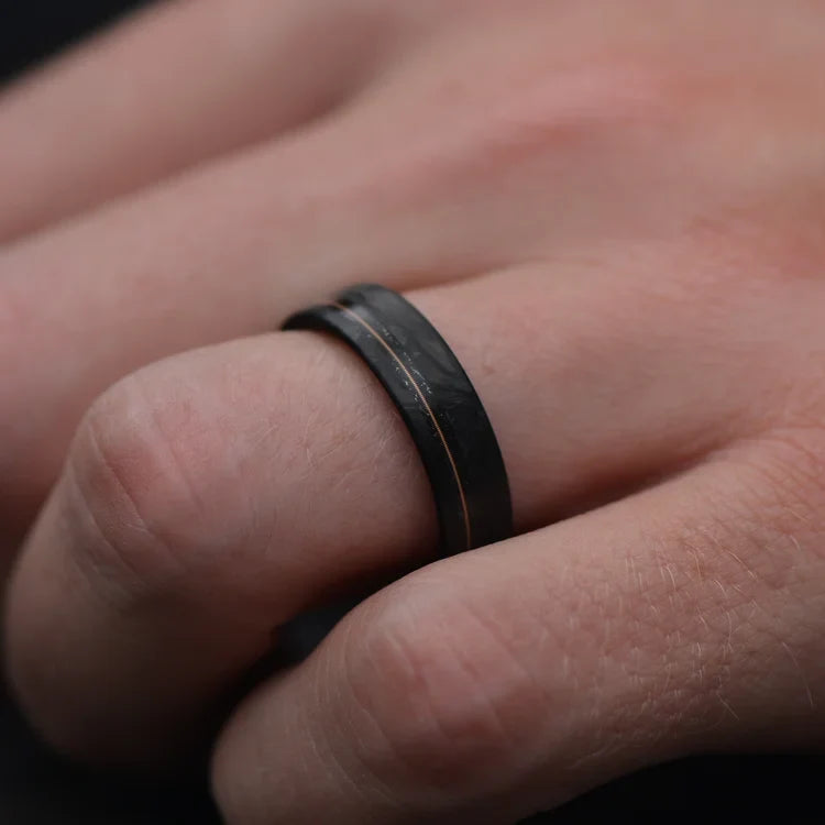 Men's matte flat profile forged wedding band with meteorite and guitar string inlay, featuring a bloodwood inner sleeve, 6mm width, shown on a hand, free engraving available.