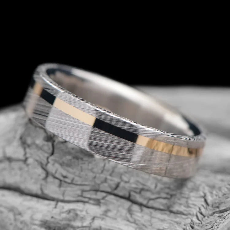 Heimskringla mens wedding band with 14K yellow gold inlay and titanium inner sleeve, polished flat profile, 6mm, displayed on a white sea branch, free engraving available.