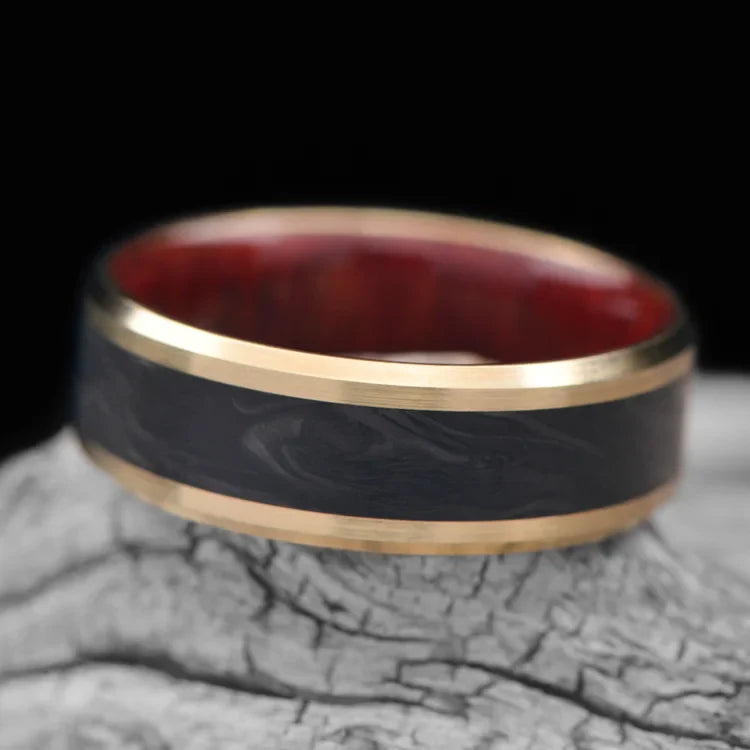 10KY Gold Wedding Band with Central Forged Inlay and Bloodwood Inner Sleeve, Mens 7mm Wedding Ring, Brushed Beveled Profile, Free Engraving, displayed on white sea branch.