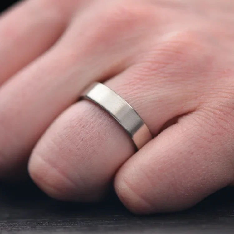 14KW mens wedding band with moonstone inner sleeve, brushed flat profile, 6mm width, custom ring with free engraving, shown on a hand.