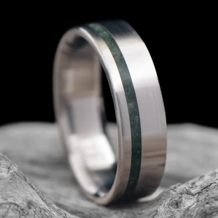 Titanium wedding band with moss agate inlay, 6mm mens ring, brushed flat profile, unique design, displayed on white sea branch, free engraving available.