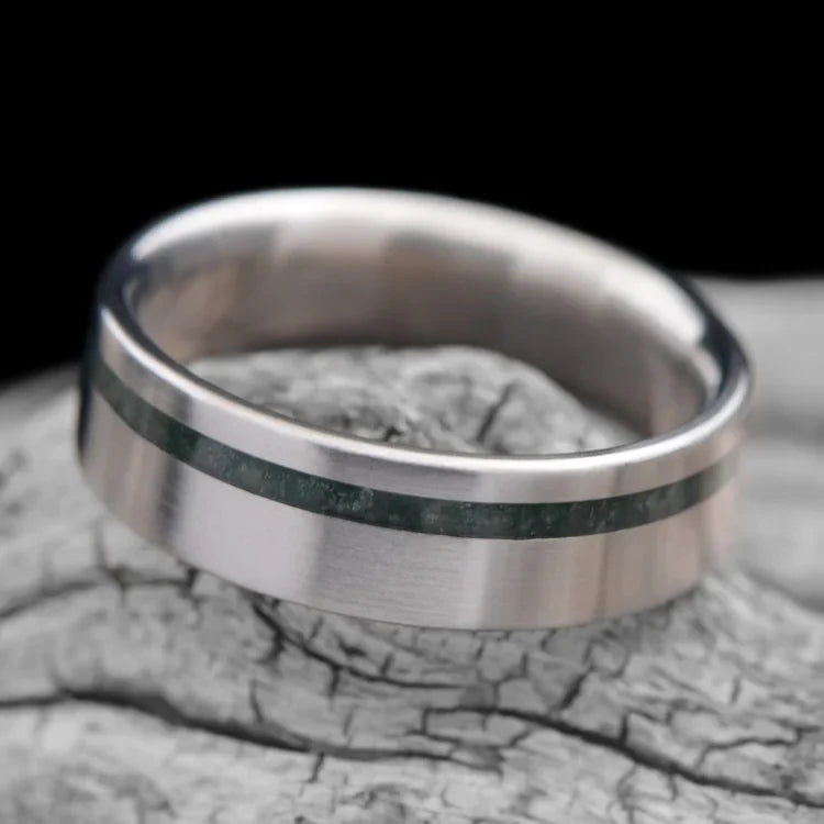 Titanium wedding band with moss agate inlay, 6mm mens ring, brushed flat profile, unique design, free engraving, displayed on white sea branch.